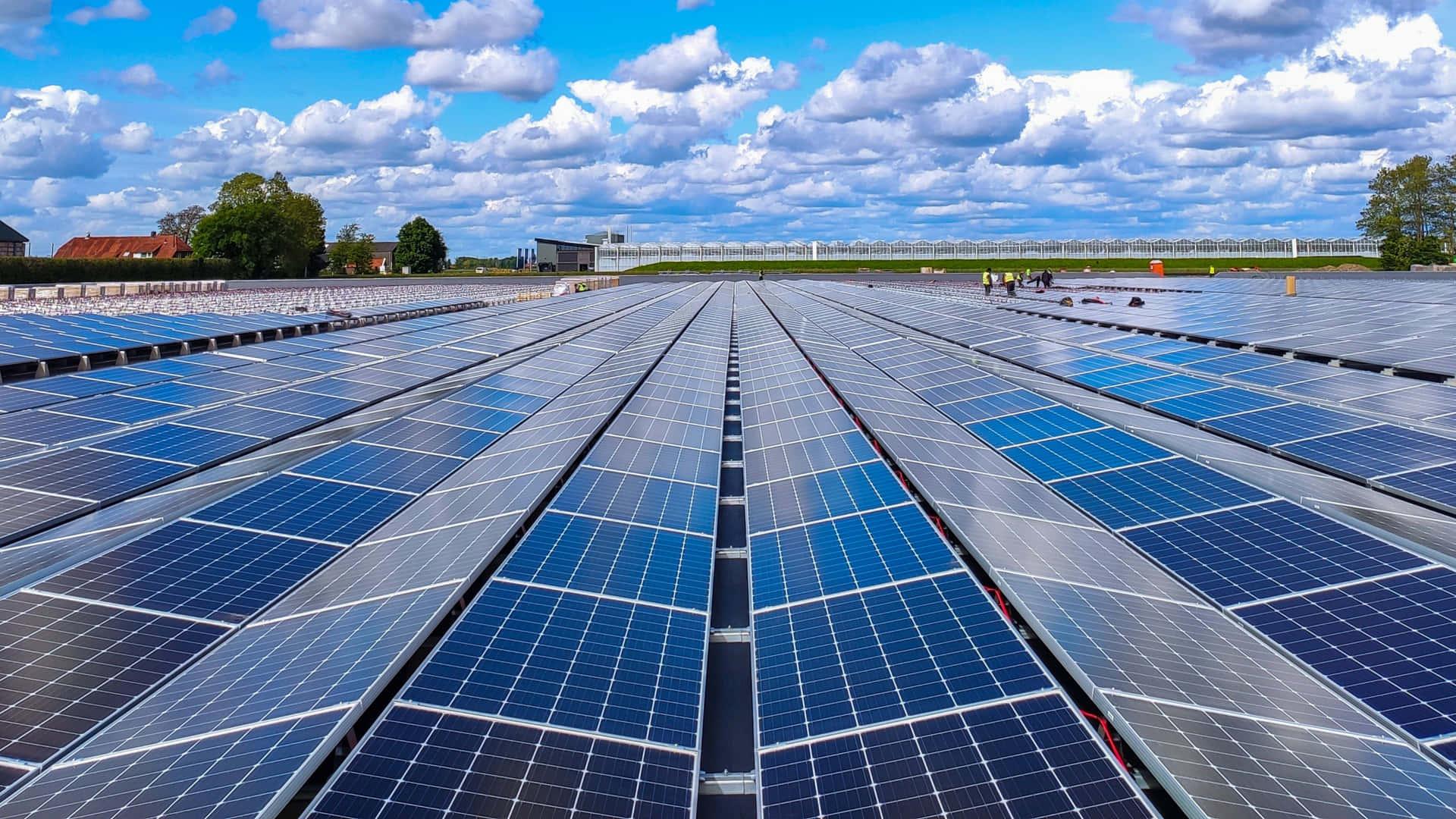 Large scale solar panel installation under a blue sky with clouds
